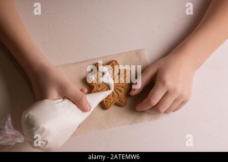 Un garçon de 10 ans vire les cookies avec un sac culinaire. Fait Main. La créativité des enfants Banque D'Images