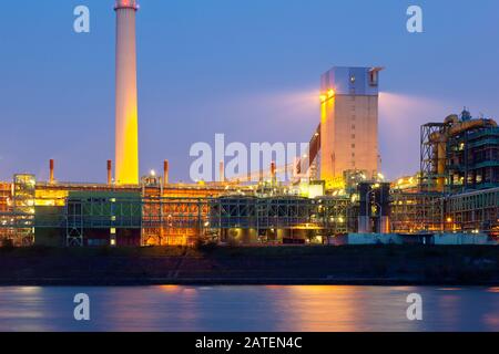 Une usine de cokage vue sur une rivière avec ciel bleu de nuit. Banque D'Images