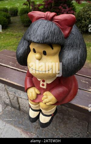 Sculpture de Mafalda par l'artiste Pablo Irrgang avec robe rouge assise sur un banc dans le parc urbain de Campo de San Francisco (Oviedo, Asturies, Espagne) Banque D'Images