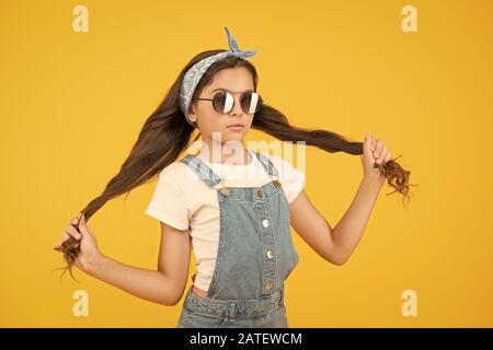 Cheveux forts. Fille de long cheveux bouclés attachés lunettes de foulard. Tendance de la mode. Vous pouvez avoir tout ce que vous voulez si robe pour elle. Peu de fashionista. Cute kid fashion girl. @Summer mode concept. Banque D'Images