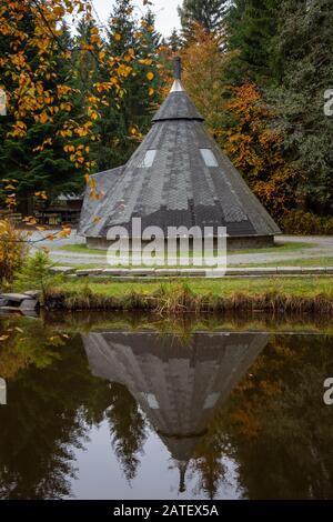 un petit lac dans une forêt avec un cottage en automne Banque D'Images