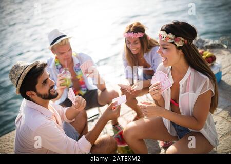 Groupe d'amis créatifs assis à table en bois. Les gens s'amuser tout en jouant à jeu de plateau. Banque D'Images