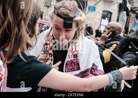 Jérusalem, Israël. 2 février 2020. Une jeune femme est enveloppée dans le tefillin, ou phylactères, dans un stand de wrap pour les femmes organisé par les femmes du mur, une organisation connue pour lutter pour les droits de prière des femmes au mur occidental, dans le centre-ville de Jérusalem. Tefillin, deux petites boîtes noires contenant du parchemin avec des versets de la Bible hébraïque sont enroulées autour de la tête et du bras avec des sangles en cuir noir et sont considérées comme un commandement dans le judaïsme orthodoxe. En tant que tels, ils sont traditionnellement le domaine des hommes seulement. Crédit: Nir Alon/Alay Live News. Banque D'Images