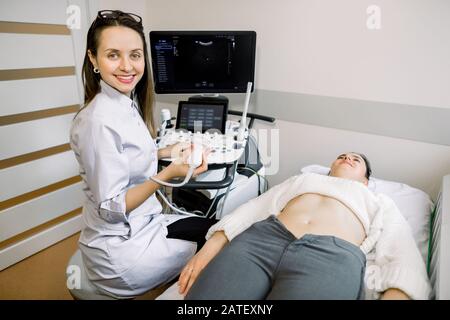 Médecin souriant, concept d'échographie. Le médecin a effectué une échographie pour les jeunes femmes dans un centre médical moderne Banque D'Images