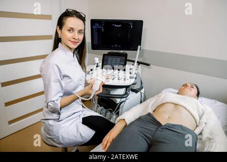 Médecin souriant, concept d'échographie. Le médecin a effectué une échographie pour les jeunes femmes dans un centre médical moderne Banque D'Images