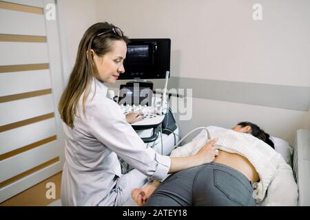 Échographie en thérapie physique. Jeune femme thérapeute utilisant un échographe sur la patiente dans le bas du dos. Échographie du dos et du rein. Banque D'Images