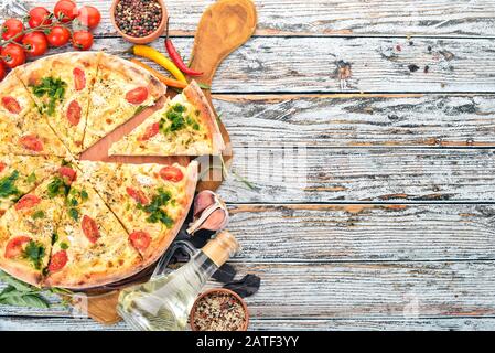 Pizza aux tomates cerises, au sulugni et au basilic. Cuisine italienne. Sur un fond en bois. Espace libre pour le texte. Vue de dessus. Banque D'Images