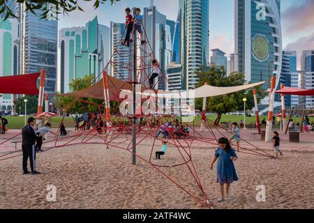 Le Sheraton Park de Doha Qatar offre une vue sur la lumière du jour avec des enfants jouant dans l'aire de jeux pour enfants et la ligne d'horizon avec des nuages dans le ciel en arrière-plan Banque D'Images