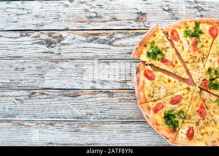 Pizza aux tomates cerises, au sulugni et au basilic. Cuisine italienne. Sur un fond en bois. Espace libre pour le texte. Vue de dessus. Banque D'Images