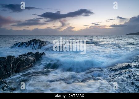 Un jet magique d'eau salée misteuse sur les rochers au coucher du soleil à Bovisand dans Devon Banque D'Images