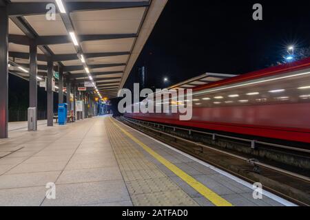 Gare de London Mudchute DLR avec un train rapide qui traverse. Banque D'Images