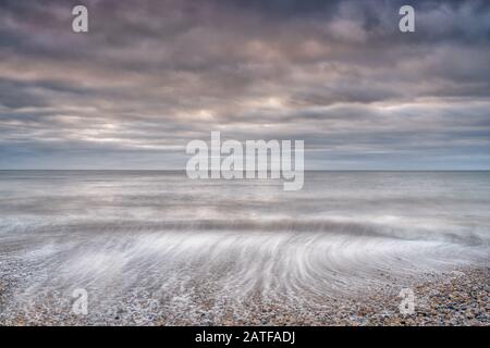 Spectaculaire ciel tôt le matin à la plage de Pagham, West Sussex Banque D'Images