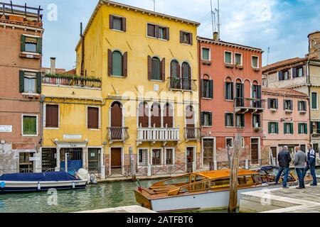 Beau bâtiment ancien le long du canal rio de santa fosca, alors que les gens embardent dans un bateau-taxi dans Le quartier de Cannaregio, Venise, Italie Banque D'Images