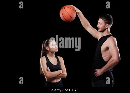 Un jeune entraîneur de basket-ball musculaire tenant le ballon sur la coupe sportive Banque D'Images