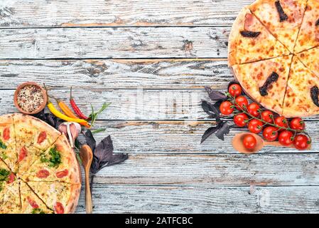 Pizza. Cuisine italienne. Sur un fond en bois blanc. Espace libre pour le texte. Vue de dessus. Banque D'Images