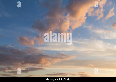 Beaux nuages et fond de ciel bleu au coucher du soleil avec des tons violet et rose sur l'Angleterre Royaume-uni. Skyscape Cloudscape et toile Banque D'Images