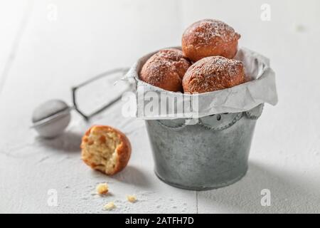 Mini beignets faits maison chauds et fraîchement cuits dans un petit seau Banque D'Images