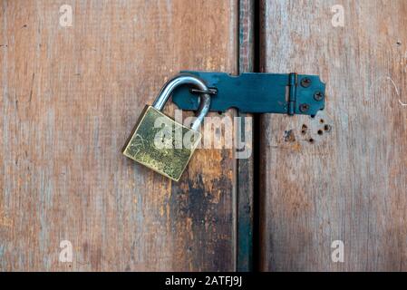 Gros plan photo d'un cadenas classique en acier de sécurité trouvé sur la porte en bois d'une maison