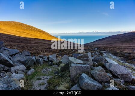 Les montagnes de Mourne sont les montagnes les plus hautes et les plus spectaculaires d'Irlande du Nord. Vue depuis la vallée près du sommet de la montagne Slieve Donard sur la mer d'Irlande Banque D'Images