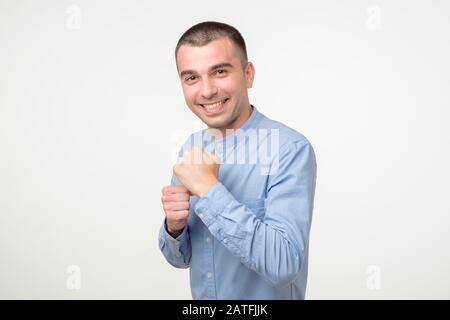 Beau jeune homme hispanique dans la lutte contre le sourire et rire. Émotion faciale positive. Banque D'Images