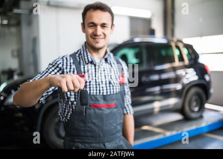 Mécanicien vous donnant les clés de voiture Banque D'Images