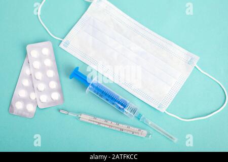 fournitures médicales anti-virus, protection contre les colds. thermomètre, comprimés, seringue sur fond bleu. Banque D'Images