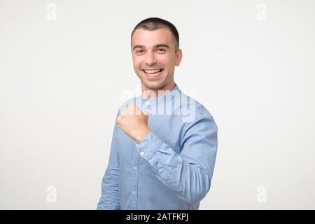 Un jeune étudiant hispanique qui a réussi à montrer un poing. Il a fait toutes ses tâches et est satisfait des résultats. Studio tourné Banque D'Images