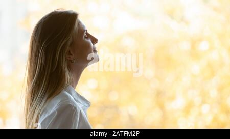 Femme d'affaires qui respirait de l'air frais près de la fenêtre avec des paysages d'automne Banque D'Images