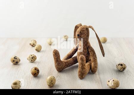 Lapin de Pâques entouré d'œufs sur une surface en bois. Banque D'Images