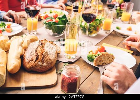 Les gens assis à la maison derrière la table, manger de la nourriture délicieuse Banque D'Images