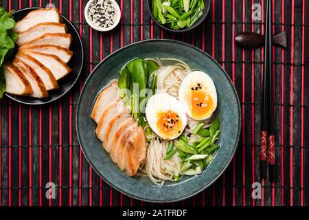 Ramen De Soupe Aux Nouilles Asiatiques Au Poulet Et Aux Œufs Servis Dans Un Bol Sur Tapis De Bambou. Vue De Dessus Banque D'Images