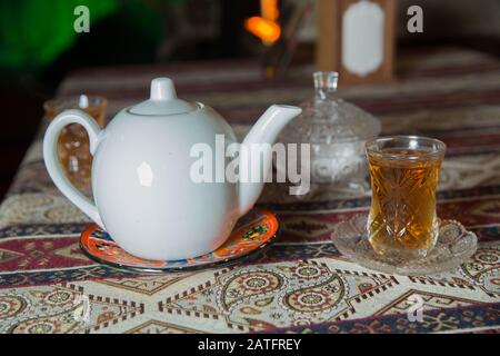 Thé dans le verre traditionnel armudu azerbaïdjanais en forme de poire . Azerbaïdjan thé noir .cubes de sucre blanc . bouilloire blanche et bol à sucre . Théière en céramique blanche Banque D'Images