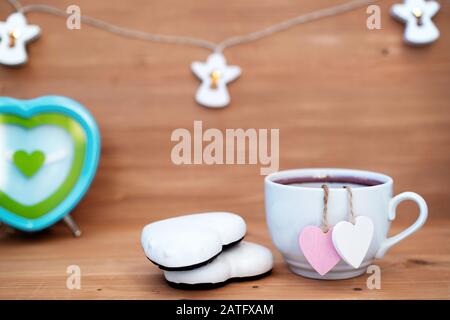 Sachet de thé en forme de coeur dans une tasse de thé blanche - mignonne déclaration d'amour sur fond de bois, foyer sélectif. Concept de Saint Valentin. Tasse de thé pour deux amoureux lune de miel mariage petit déjeuner surprise le matin Banque D'Images