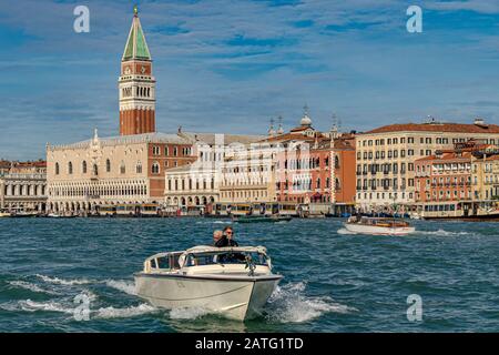 Un bateau-taxi vous conduira le long du bord de l'eau près de la Piazza San Marco avec la Tour St Marc et le Palais des Doges au loin, Venise, Italie Banque D'Images