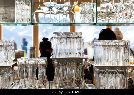 Ischgl, Autriche - 10 janvier 2020: Mur de nombreux verres à vin et à bière vides transparents sur une étagère en verre au restaurant de montagne dans la région d'Idalp Banque D'Images