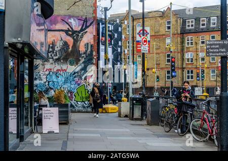 Vue sur le pavé le long de City Road à Londres, au Royaume-Uni. En arrière-plan, l'art coloré de la rue est peint sur un mur de briques Banque D'Images