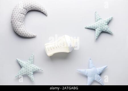 Bouteille de lait pour bébé et jouets sur fond blanc Banque D'Images