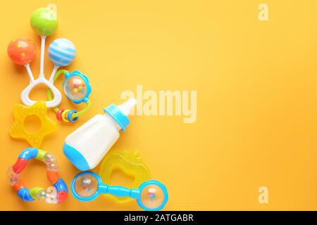 Bouteille de lait pour bébé et jouets sur fond de couleur Banque D'Images