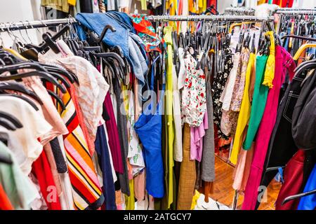 Section de dégagement bondée dans un magasin de vêtements, avec divers vêtements colorés placés étroitement sur des racks dans un ordre particulier; concept de mode rapide Banque D'Images