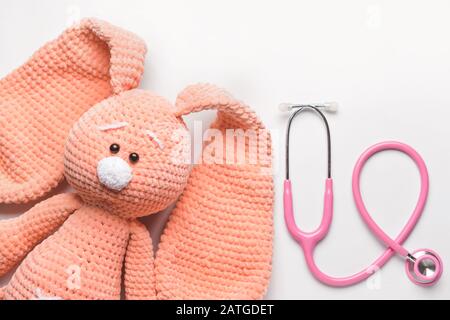 Stéthoscope et jouet pour bébé sur fond clair Banque D'Images