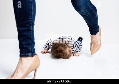 très petit enfant jetant un hantre sur le sol avec la mère marchant loin en colère et frustré Banque D'Images