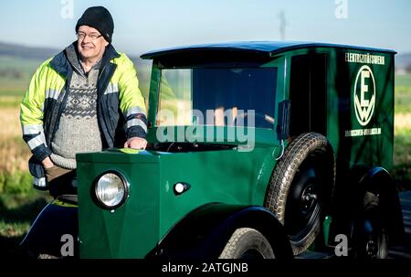 Bockenem, Allemagne. 21 janvier 2020. Horst-Dieter Görg, membre du conseil d'administration du groupe d'intérêt Hanomag, se trouve à côté de la ville et de la voiture de service électriques de 1922 'HAWA EM 3' la voiture électrique, propriété du fournisseur d'électricité BS Energy, est restaurée dans l'atelier du groupe d'intérêt Hanomag à Bockenem-Störy. Crédit: Hauke-Christian Dittrich/Dpa/Alay Live News Banque D'Images