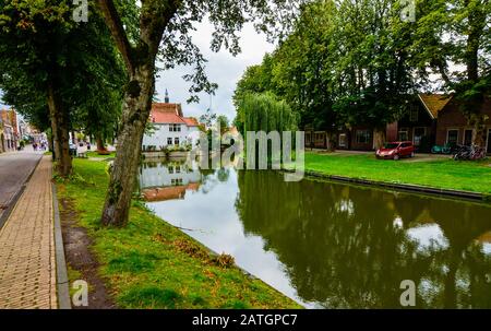 Edam, Pays-Bas, Août 2019. L'un des jolis canaux de cette ville: Le feuillage des arbres se reflète sur l'eau le long des rives, assez hous Banque D'Images