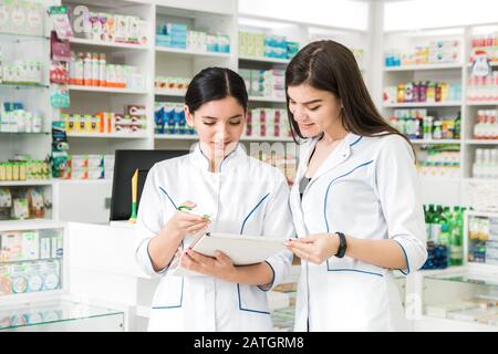 deux belles femmes pharmacien vérifiant des médicaments en pharmacie. stock inventaire Banque D'Images