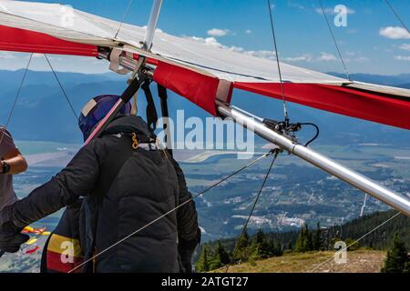 Vue rapprochée du pilote du deltaplane se préparer à voler depuis le sommet de la montagne. Parapente en haut de la colline Banque D'Images