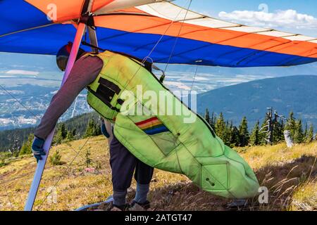 Homme avec le deltaplane se préparer à voler et à vérifier ses engrenages et son équipement. Un pilote de plan Delta sur le point de se lancer. Prise de vue moyenne Banque D'Images