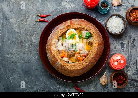 Soupe traditionnelle polonaise Zurek, dans un pain.plat national de cuisine polonaise. Banque D'Images