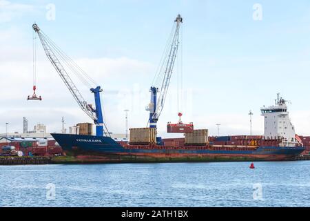 Reykjavik, Islande - 4 avril 2017 : déchargement d'un navire-conteneur amarré au port de Reykjavik à la journée enneigée du printemps Banque D'Images