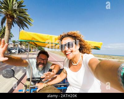 Joyeux et joyeux couple adulte magnifique profitant de l'actsivité de loisirs en plein air en vacances avec louer un vélo drôle ensemble riant beaucoup et ayant f Banque D'Images