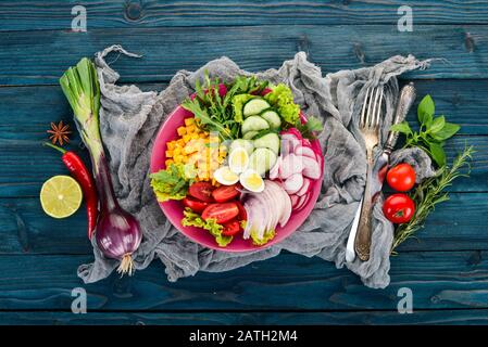 Salade De Légumes Frais. Maïs, radis, oignon, concombre, œufs de caille. Sur un fond en bois. Vue de dessus. Espace de copie disponible. Banque D'Images